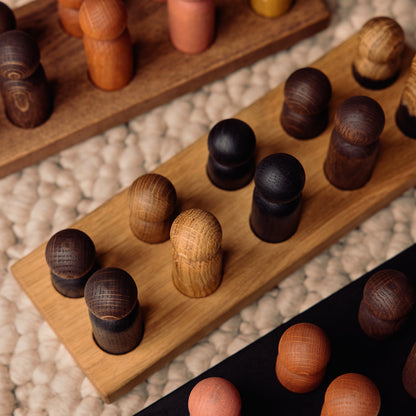 Montessori-inspired wooden pegboard toy in Natural Oak with Mono Palette by Woodsie Wonder, shown in close-up detail.