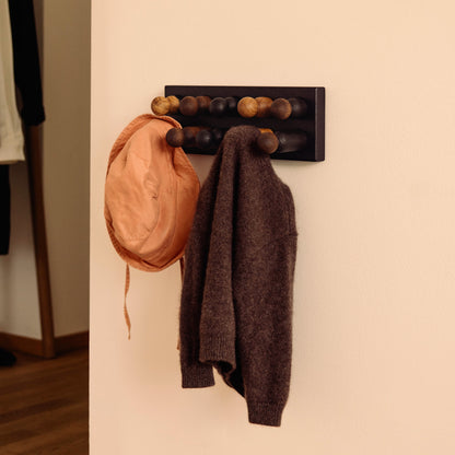 Wooden children’s wall coat rack and sorting toy in one by Woodsie Wonder – Play & Hang in Black Oak with Mono Palette, designed as a sorting toy that transforms into playful wall storage.