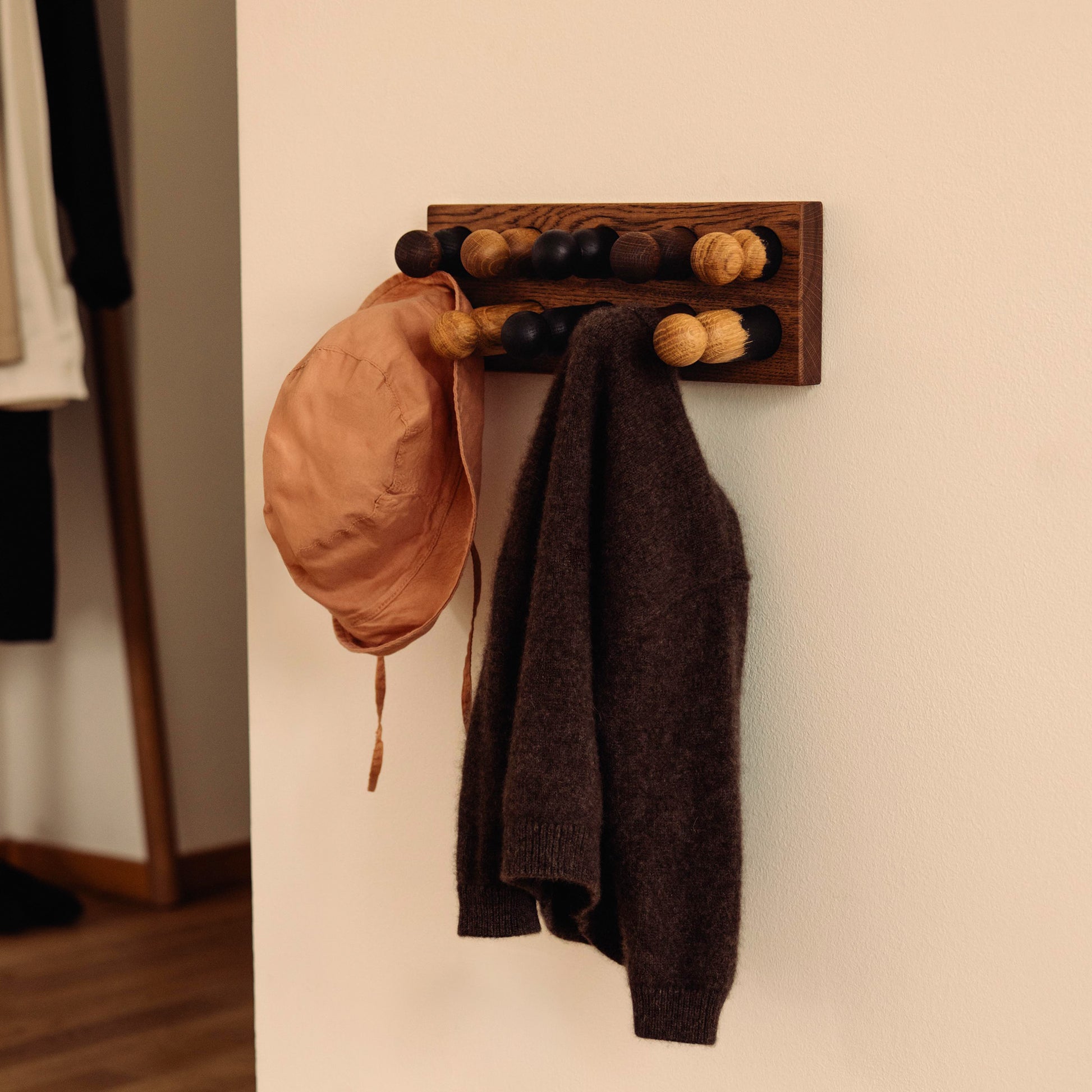 Wooden children’s wall coat rack and sorting toy in one by Woodsie Wonder – Play & Hang in Brown Oak with Earth Palette, designed as a sorting toy that transforms into playful wall storage.