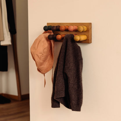 Wooden children’s wall coat rack and sorting toy in one by Woodsie Wonder – Play & Hang in Natural Oak with Earth Palette, designed as a sorting toy that transforms into playful wall storage.