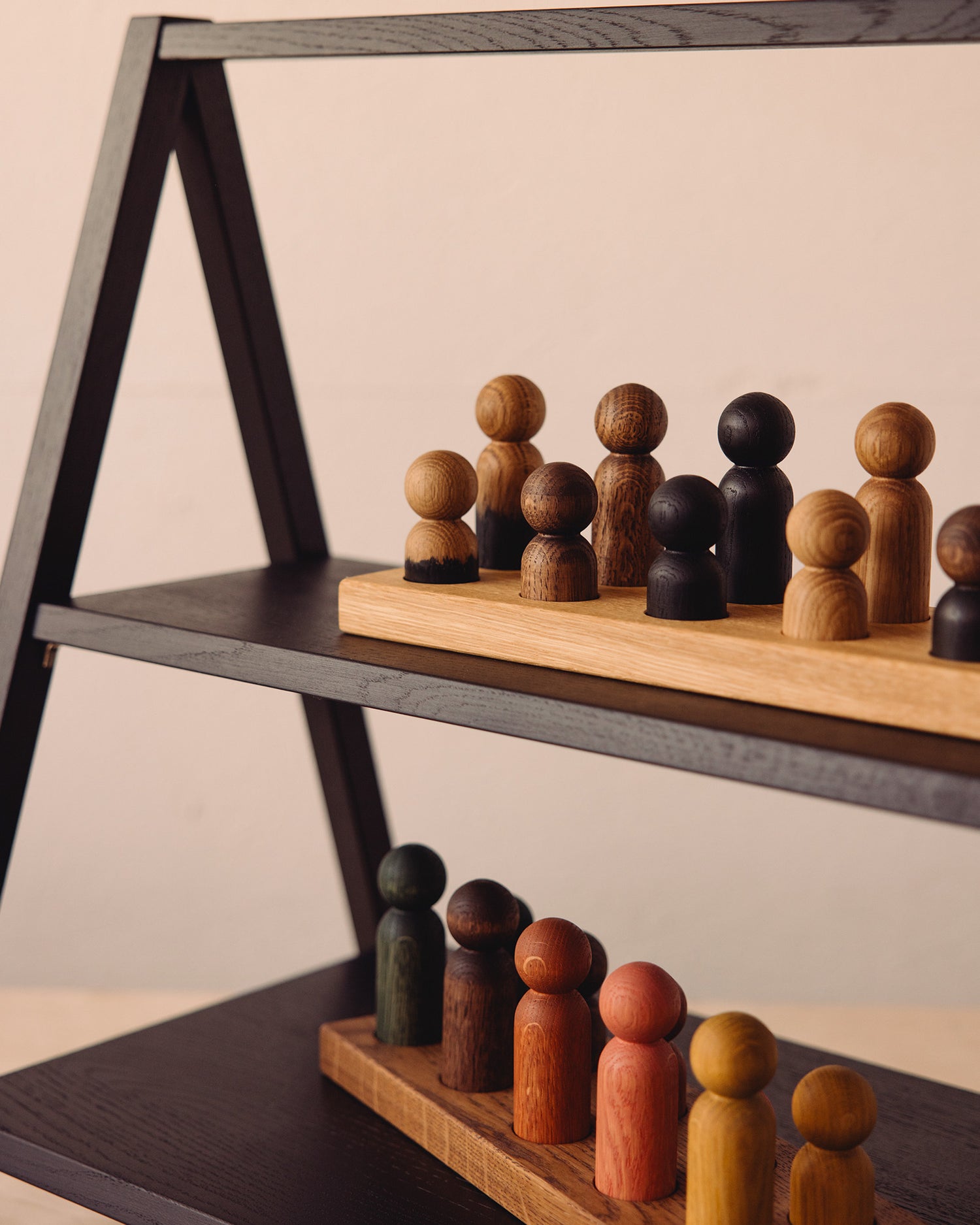 Close-up of Play & Hang wooden pieces displayed on a Black Oak shelf in the Woodsie Wonder workshop.