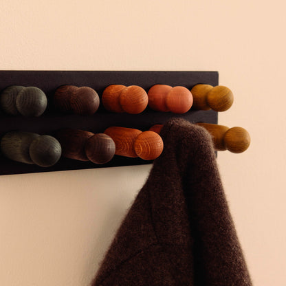 Wooden kids wall hooks in Black Oak with Earth Palette, shown in close-up detail as part of the Play & Hang coat rack by Woodsie Wonder.