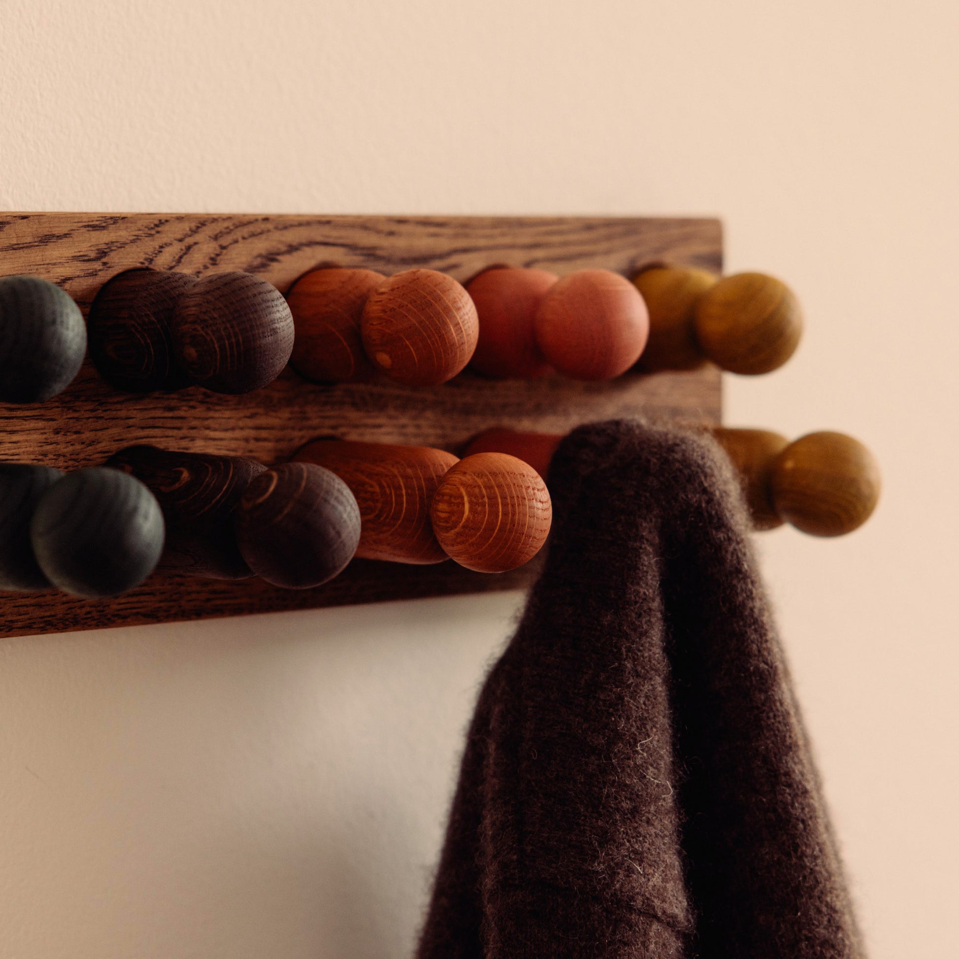 Wooden kids wall hooks in Brown Oak with Earth Palette, shown in close-up detail as part of the Play & Hang coat rack by Woodsie Wonder.