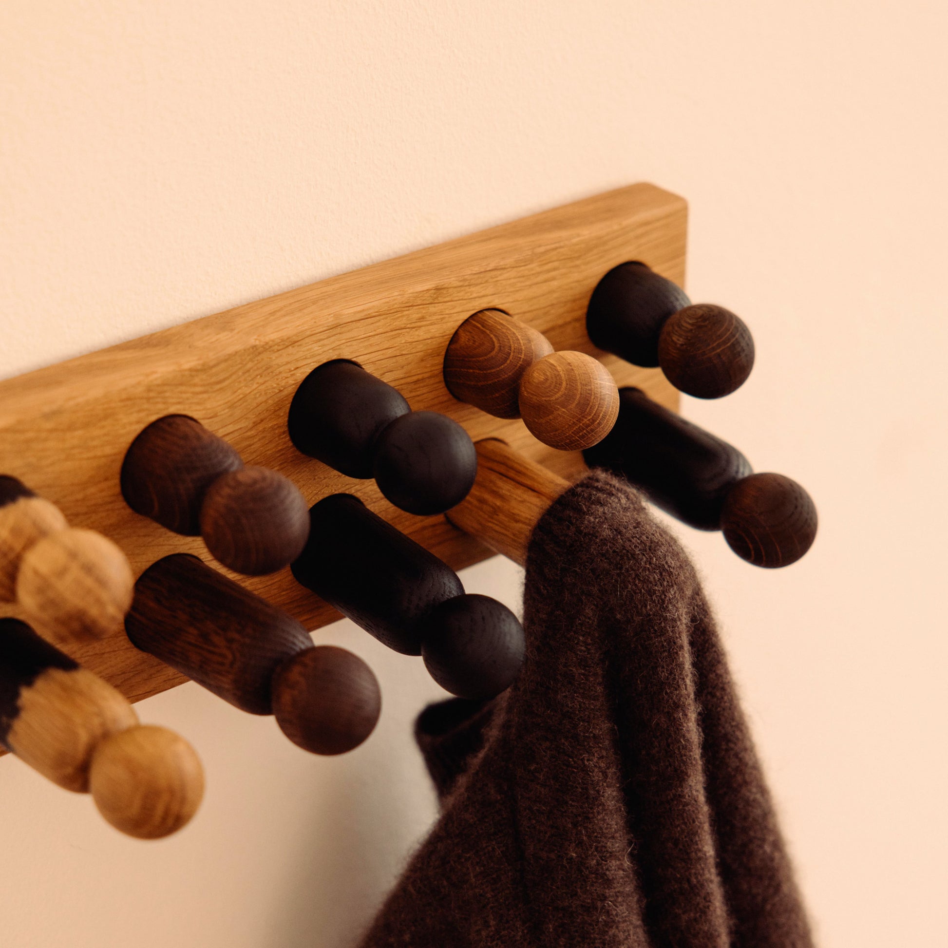 Wooden kids wall hooks in Natural Oak with Mono Palette, shown in close-up detail as part of the Play & Hang coat rack by Woodsie Wonder.
