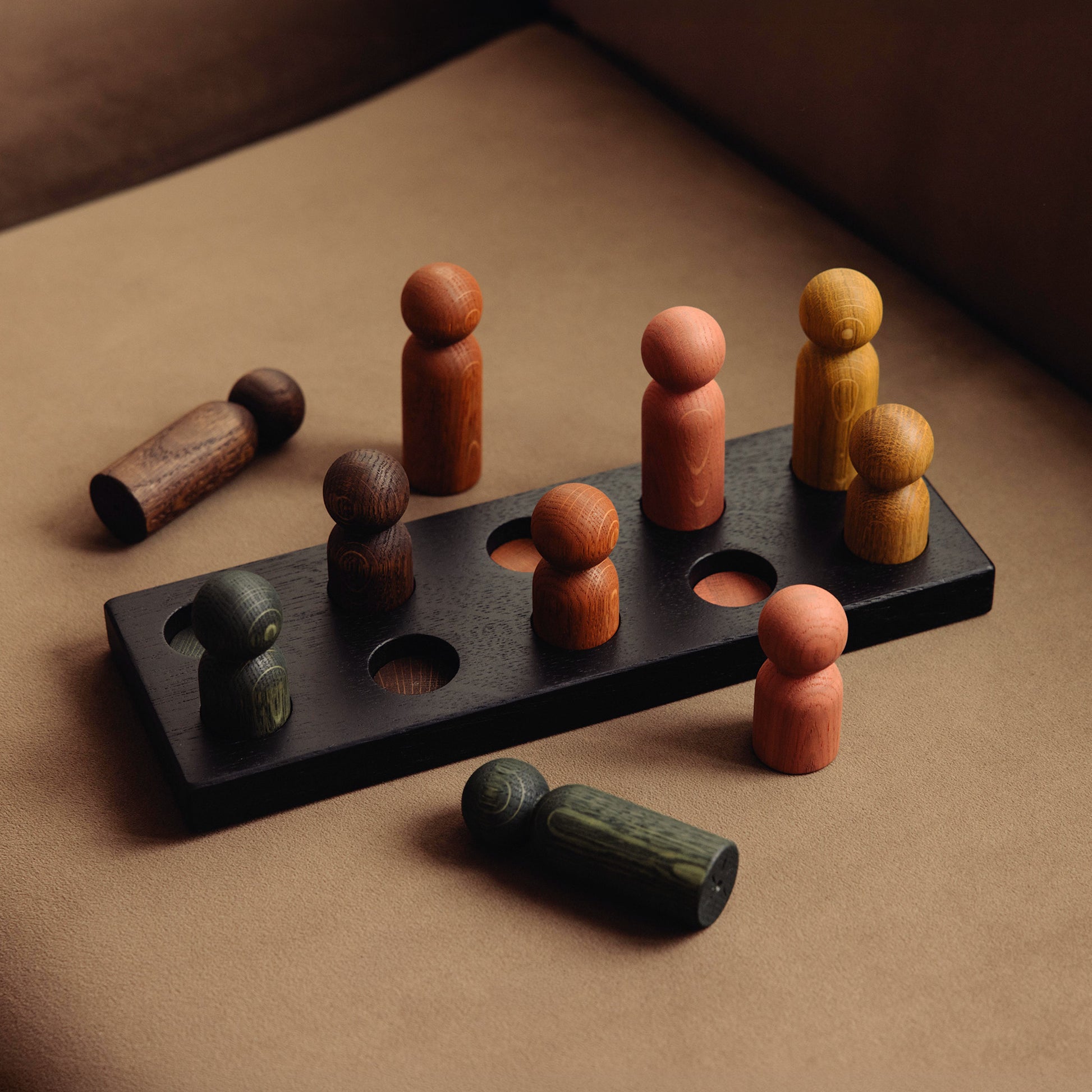 Wooden pegboard sorting toy by Woodsie Wonder in Black Oak with Earth Palette, designed for colour matching, fine motor play and later use as a children’s coat rack.