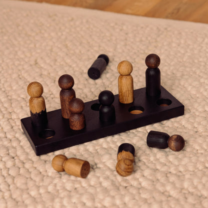 Wooden pegboard sorting toy by Woodsie Wonder in Black Oak with Mono Palette, designed for colour matching, fine motor play and later use as a children’s coat rack.