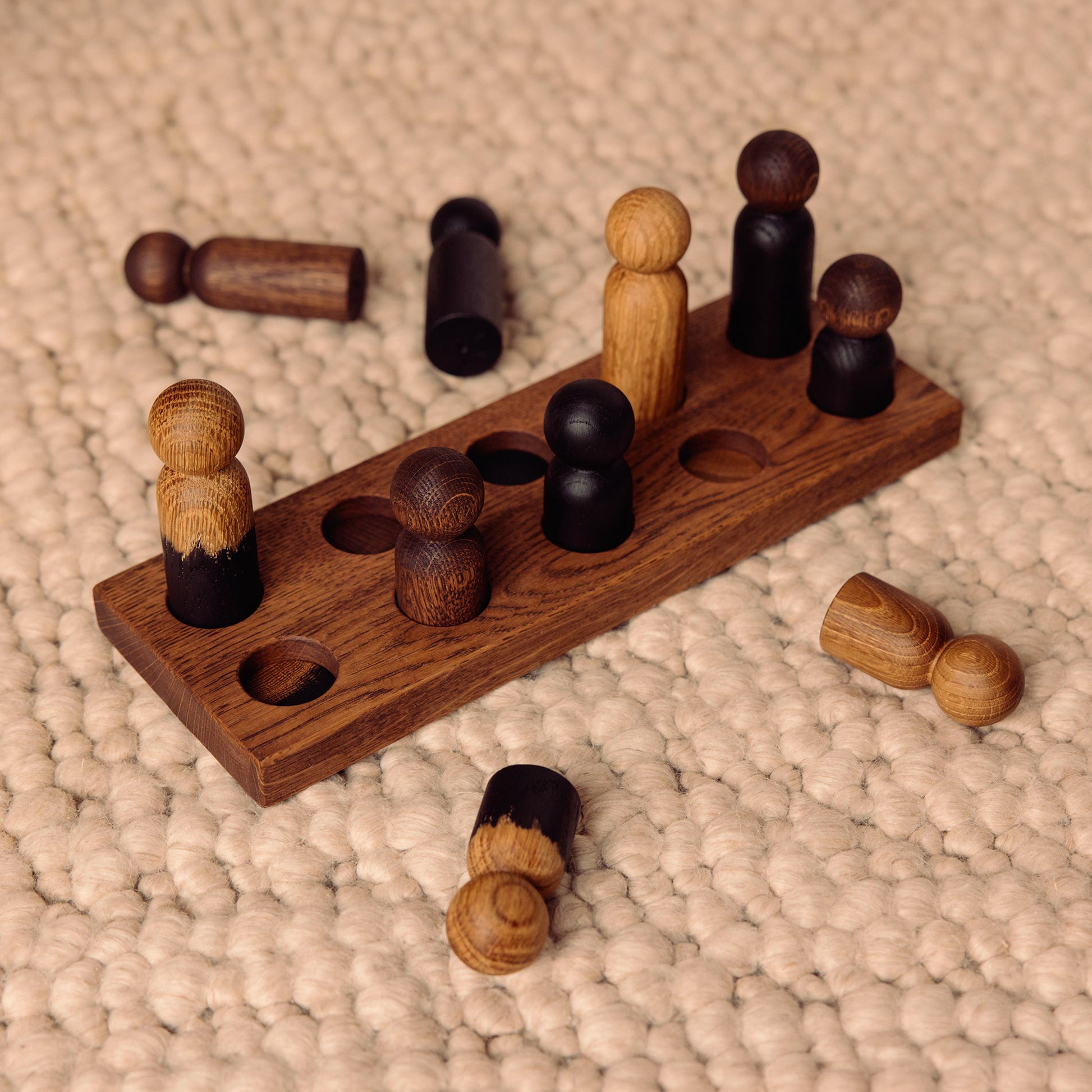 Wooden pegboard sorting toy by Woodsie Wonder in Brown Oak with Mono Palette, designed for colour matching, fine motor play and later use as a children’s coat rack.