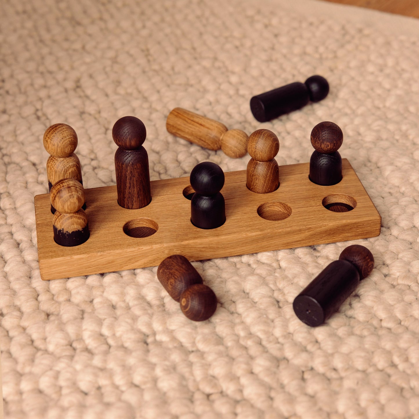 Wooden pegboard sorting toy by Woodsie Wonder in Natural Oak with Mono Palette, designed for colour matching, fine motor play and later use as a children’s coat rack.