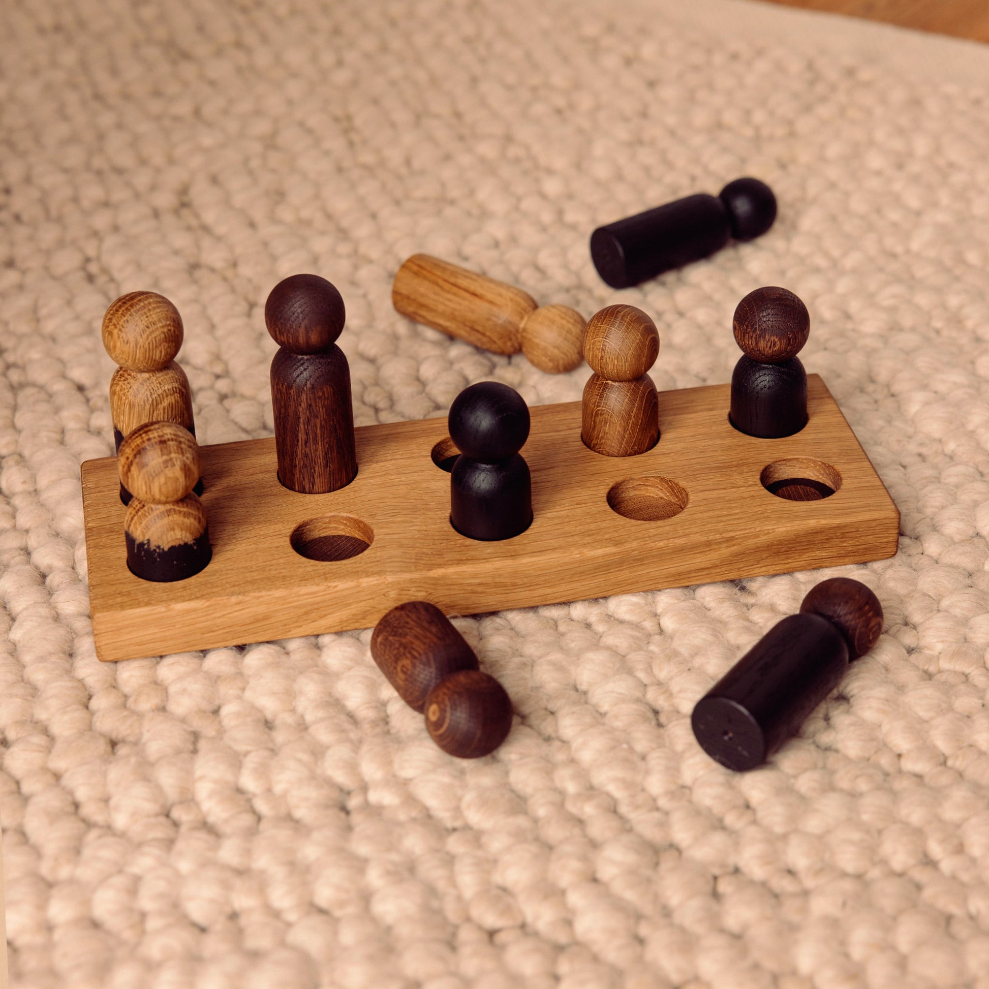 Wooden pegboard sorting toy by Woodsie Wonder in Natural Oak with Mono Palette, designed for colour matching, fine motor play and later use as a children’s coat rack.