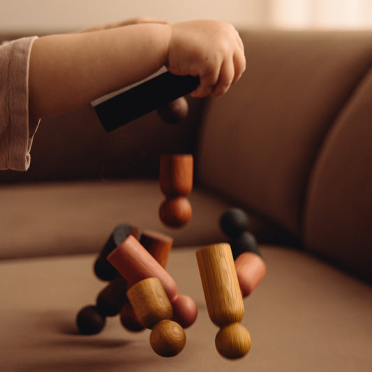 Child playing with wooden Play & Hang pieces by Woodsie Wonder, representing the digital gift card.